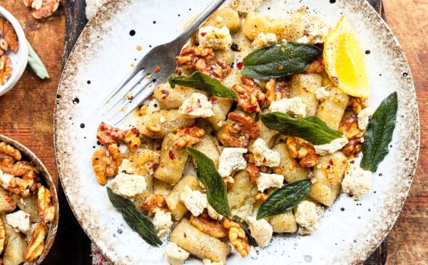 a plate of homemade gnocchi with sage, walnuts, and vegan blue cheese
