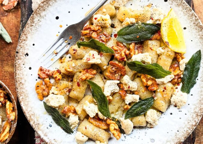 a plate of homemade gnocchi with sage, walnuts, and vegan blue cheese