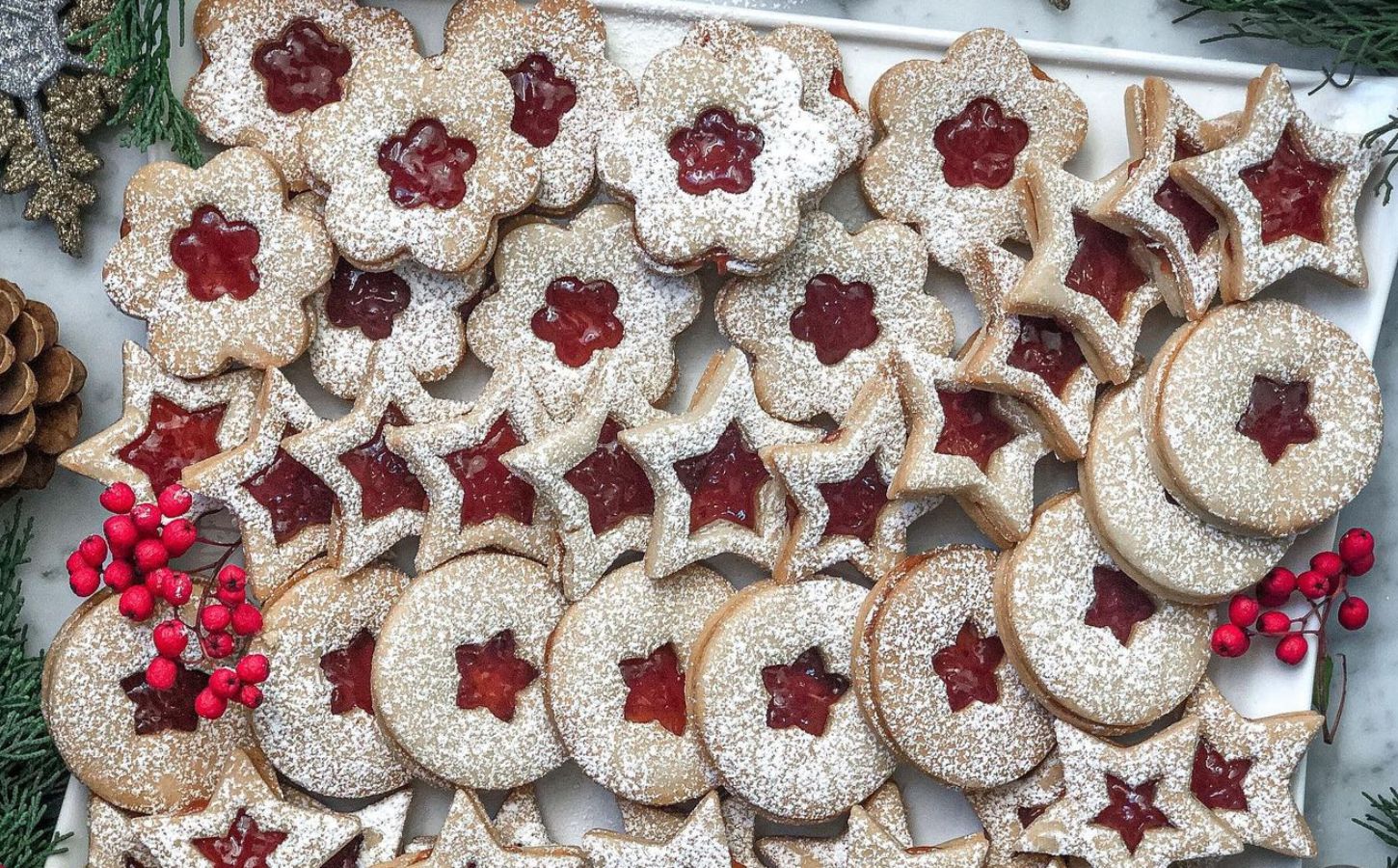 a tray of linzer cookies with strawberry jam