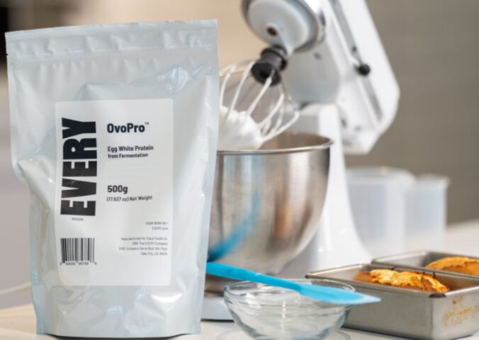 Photo shows a bag of The Every Company's powdered, precision fermented egg protein next to baking equipment and two small cakes