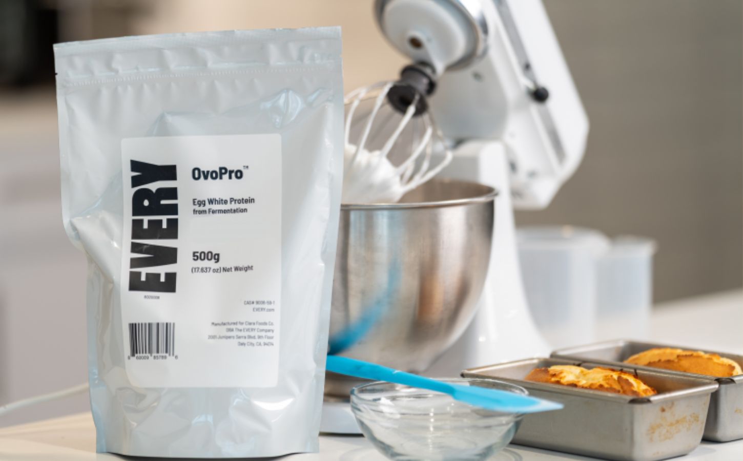Photo shows a bag of The Every Company's powdered, precision fermented egg protein next to baking equipment and two small cakes