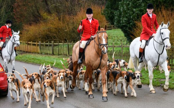 Photo shows huntsman John Holliday and whippers-in Sam and Poppy with the Duke of Rutland's hounds for The Belvoir Hunt's Boxing Day meet in December 2021