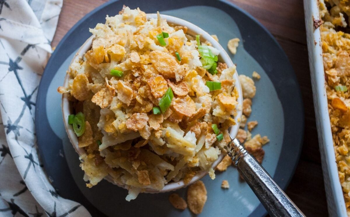 a picture of a cupful of au gratin hash brown casserole topped with cornflakes and scallion for easy casserole recipes