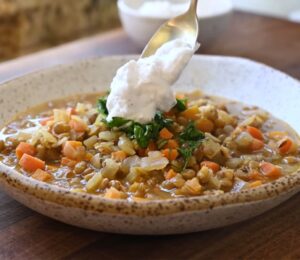 Mediterranean lentil soup finished with a spoonful of plant-based yogurt topping