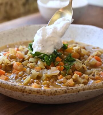 Mediterranean lentil soup finished with a spoonful of plant-based yogurt topping