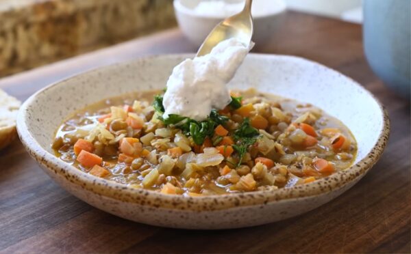 Mediterranean lentil soup finished with a spoonful of plant-based yogurt topping