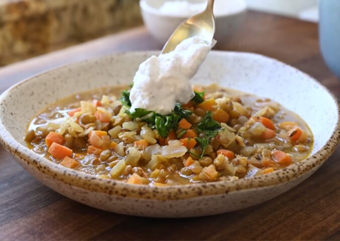 Mediterranean lentil soup finished with a spoonful of plant-based yogurt topping