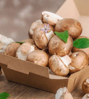 Cremini mushrooms in a box to illustrate the Mushrooms and green onions on bread to illustrate the health benefits of mushrooms