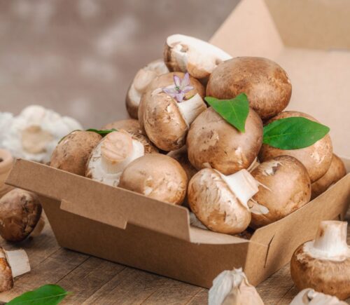 Cremini mushrooms in a box to illustrate the Mushrooms and green onions on bread to illustrate the health benefits of mushrooms