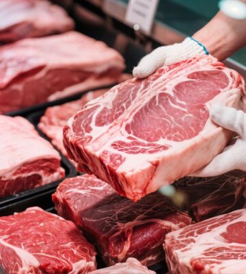 A display of raw red meat cuts in a butcher counter, illustrating the scary truth about eating meat.