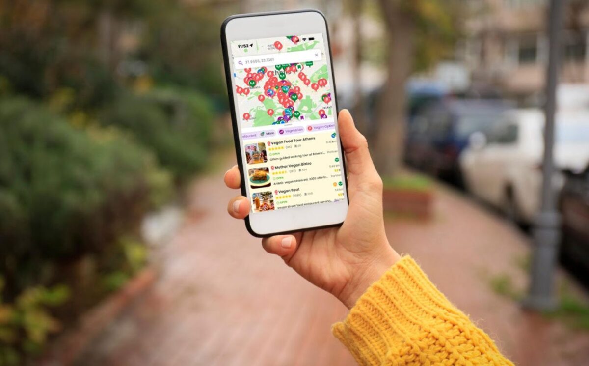 Photo shows someone's hand as they hold up a smartphone with the HappyCow app open on it. The platform recently named Asante, Barcelona, as the best vegan restaurant of 2025