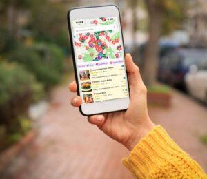 Photo shows someone's hand as they hold up a smartphone with the HappyCow app open on it. The platform recently named Asante, Barcelona, as the best vegan restaurant of 2025
