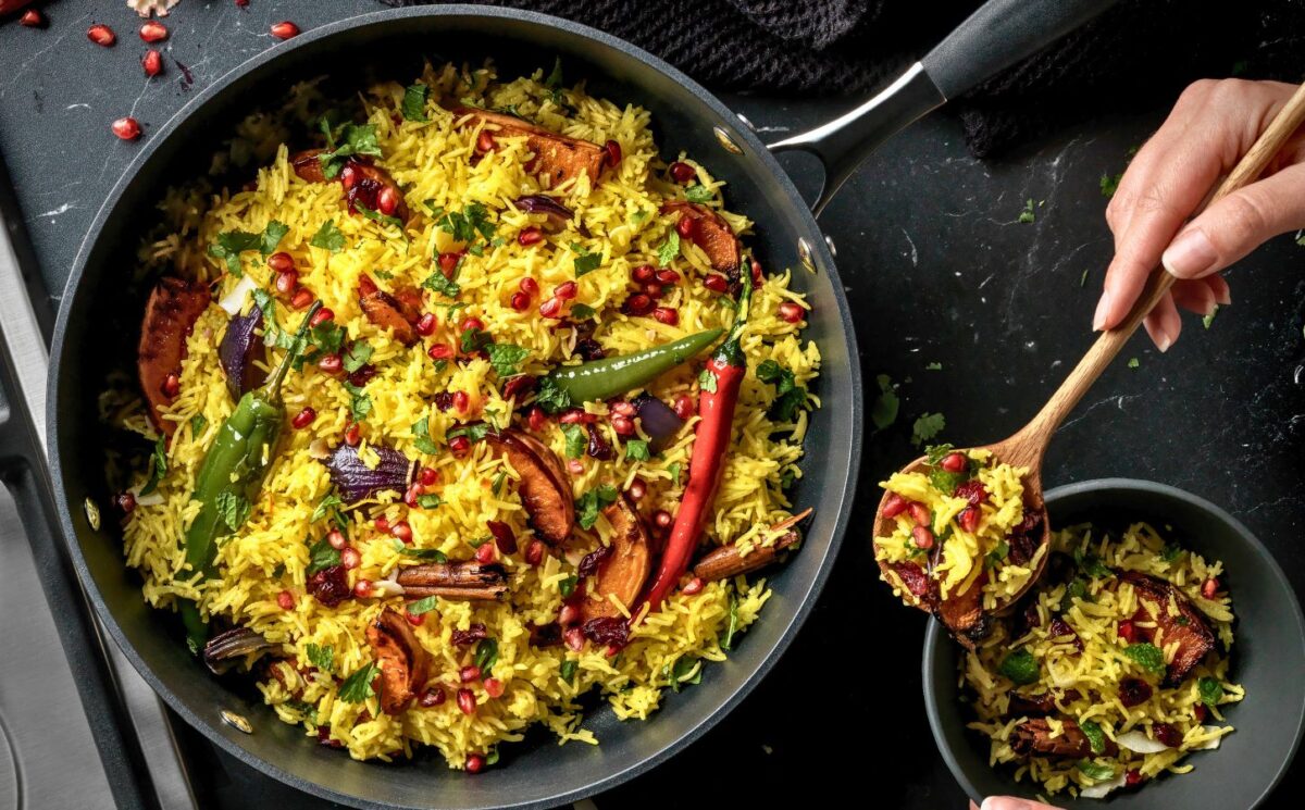 a pan full of butternut squash and pomegranate jeweled pilau rice