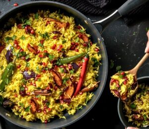 a pan full of butternut squash and pomegranate jeweled pilau rice