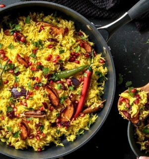 a pan full of butternut squash and pomegranate jeweled pilau rice