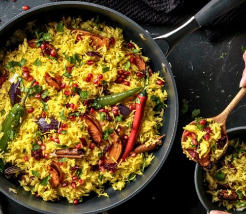a pan full of butternut squash and pomegranate jeweled pilau rice