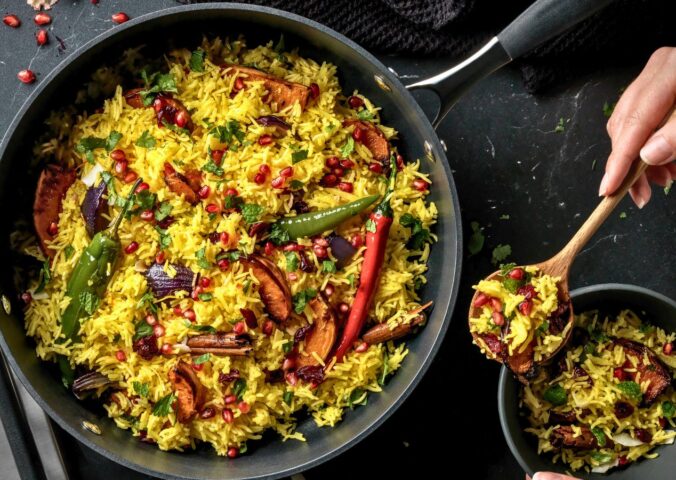 a pan full of butternut squash and pomegranate jeweled pilau rice
