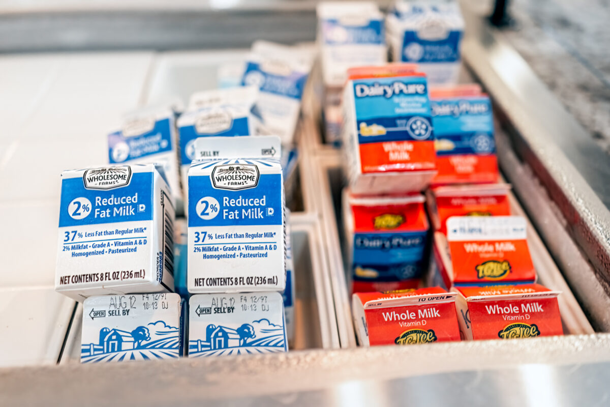 Photo shows a selection of small milk cartons in a chest refrigerator