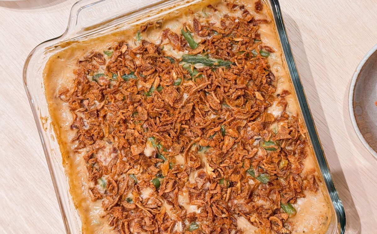 a dish of vegan parmesan bacon green bean casserole with mushroom soup and French-fried onions