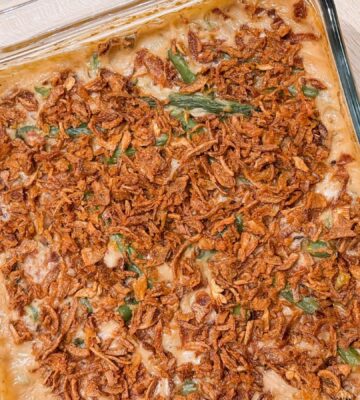 a dish of vegan parmesan bacon green bean casserole with mushroom soup and French-fried onions