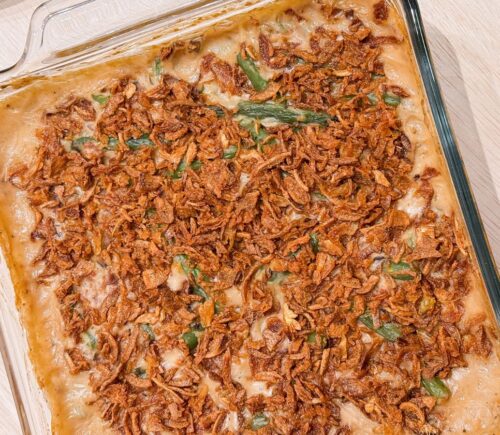 a dish of vegan parmesan bacon green bean casserole with mushroom soup and French-fried onions
