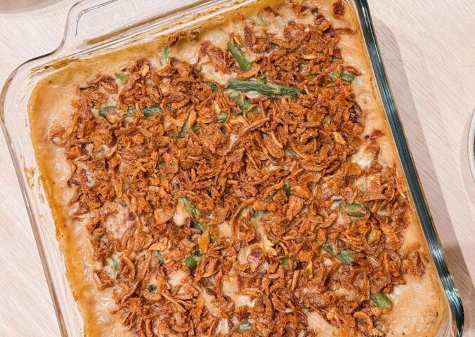 a dish of vegan parmesan bacon green bean casserole with mushroom soup and French-fried onions