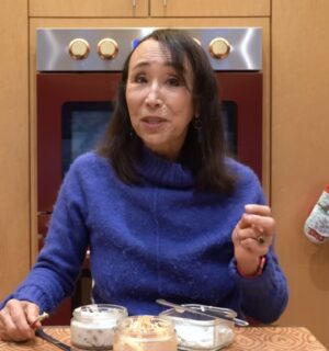 Miyoko Schinner stands behind the 3 varieties of her cashew cream cheese in her kitchen
