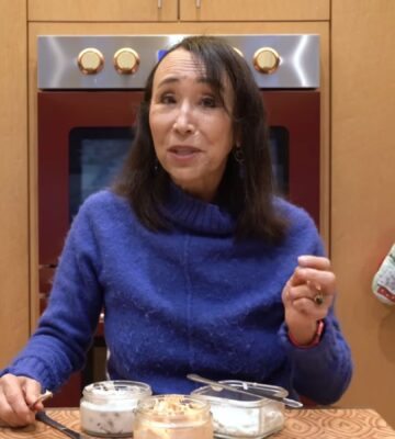 Miyoko Schinner stands behind the 3 varieties of her cashew cream cheese in her kitchen