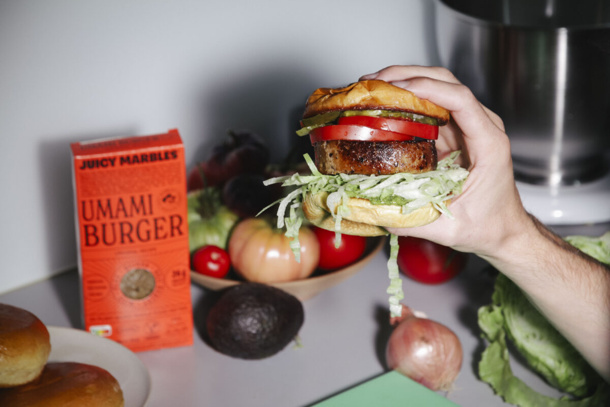 Photo shows someone's hand holding the new Umami burger from Juicy Marbles