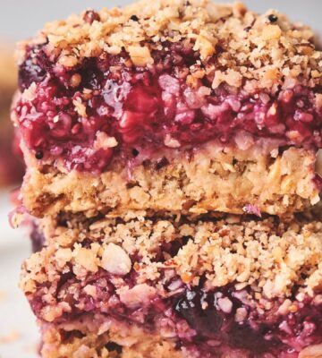 stacked breakfast berry chia bard with banana, maple syrup, rolled oats, frozen berries, and a crumble topping