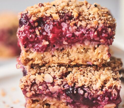 stacked breakfast berry chia bard with banana, maple syrup, rolled oats, frozen berries, and a crumble topping