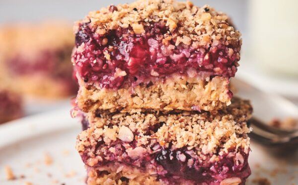 stacked breakfast berry chia bard with banana, maple syrup, rolled oats, frozen berries, and a crumble topping
