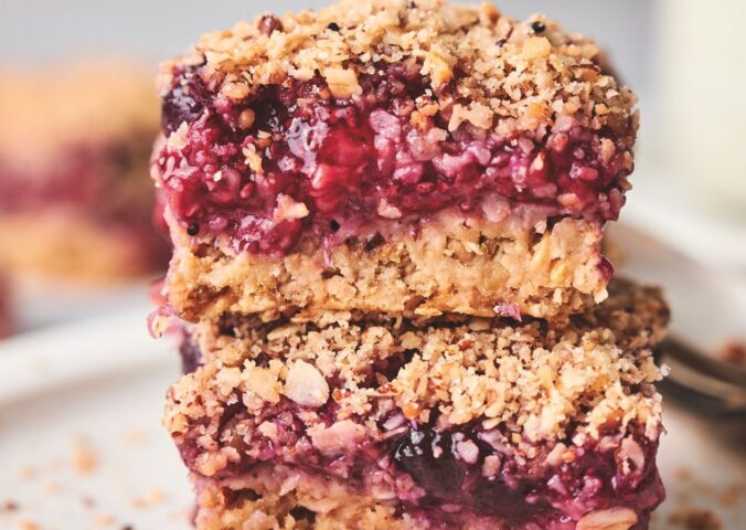 stacked breakfast berry chia bard with banana, maple syrup, rolled oats, frozen berries, and a crumble topping
