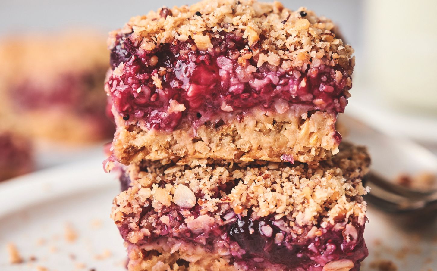 stacked breakfast berry chia bard with banana, maple syrup, rolled oats, frozen berries, and a crumble topping