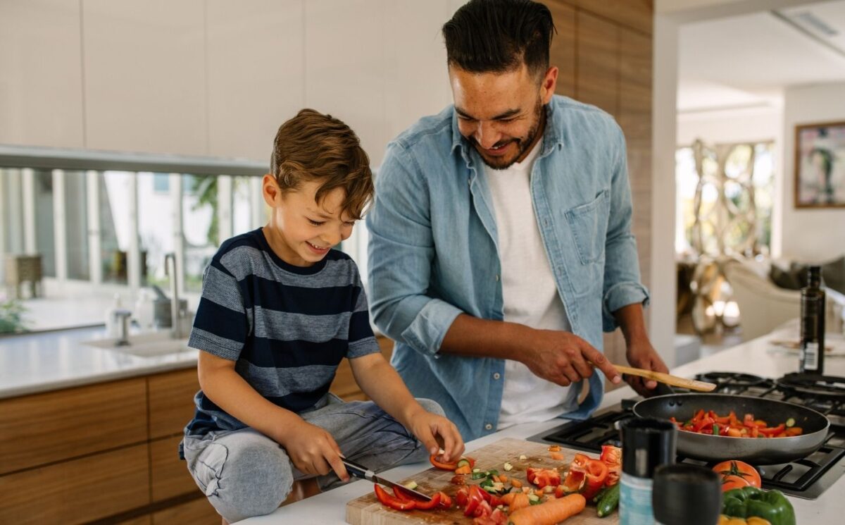Photo shows a man and his son preparing and cooking vegetables in a kitchen. According to a new survey, the majority of Canadians would like to eat more plant-based foods.