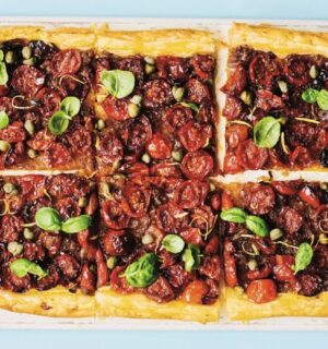 a picture of six squares of a caramelized shallot and tomato tart topped with basil and capers for vegan savory tart ideas for both sweet and savory recipes