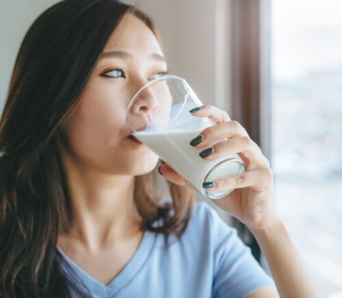Photo shows a young woman drinking milk while looking out of her kitchen window. New research by Danone and INNOFACT has found that nearly half of German adults now drink plant-based milk alternatives