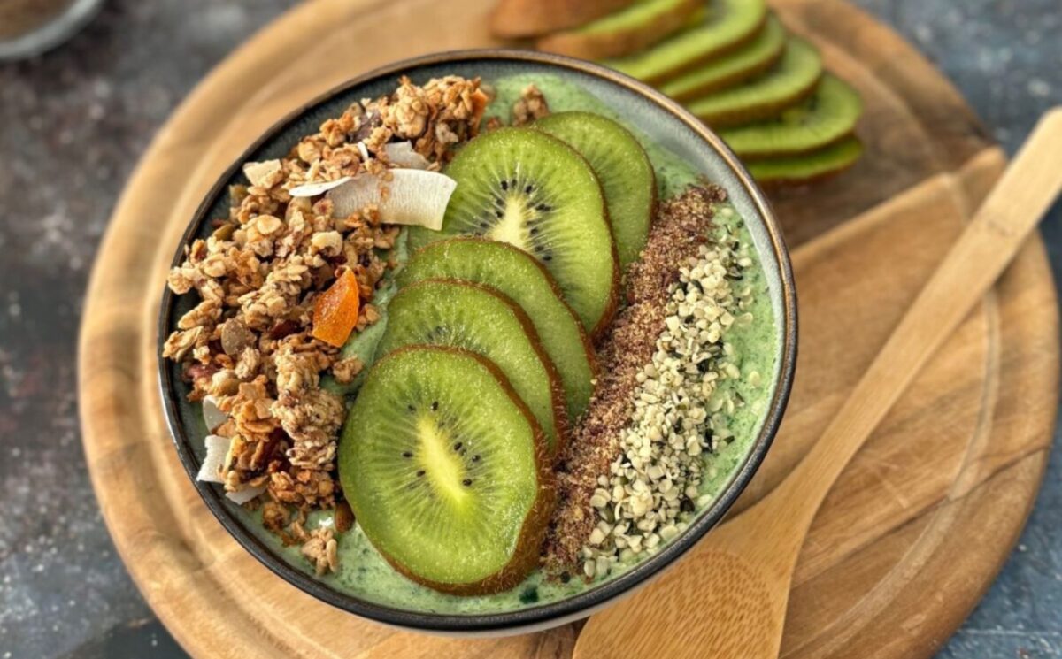 A green smoothie bowl with fruit and granola toppings, a healthy plant-based breakfast for vegan recipes for one