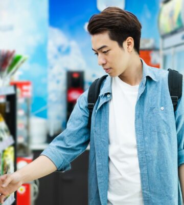 Photo shows a young man about to pick up a food production from a supermarket shelf. A new study’s “promising results” indicate that emphasizing protein on plant-based food labels is the most effective way of improving consumer uptake