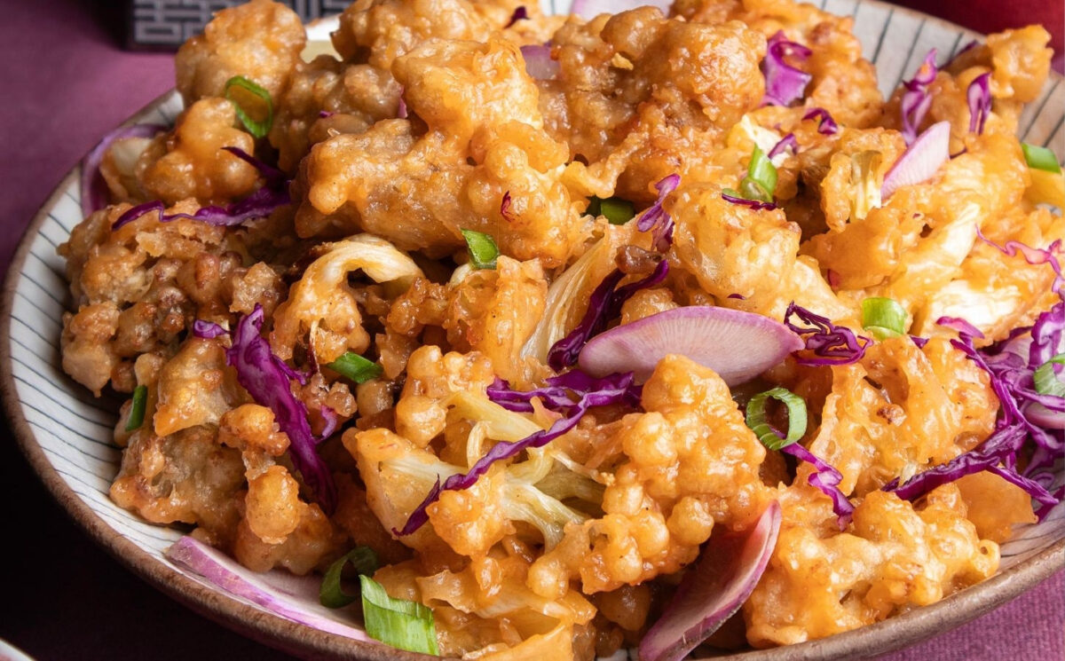 a plate of fried sweet and sour cauliflower with garnish for weeknight vegan dinners
