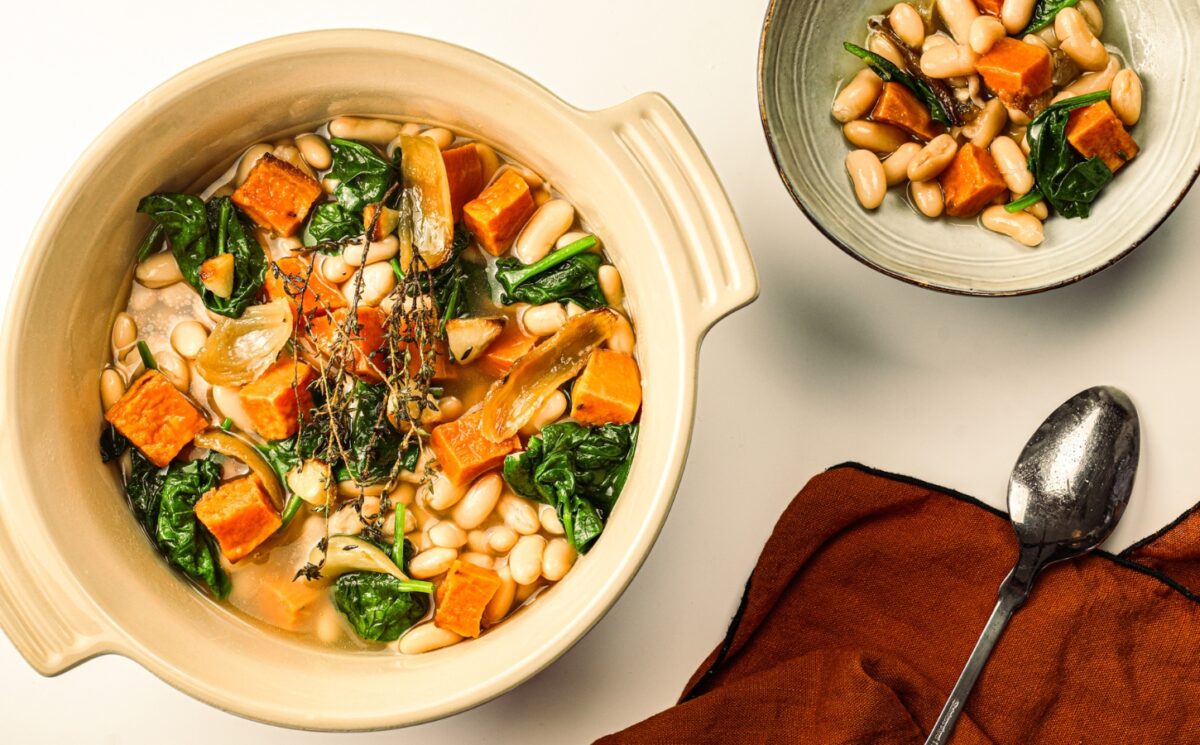 A pot of sweet potato one-pot warmer with spinach, white beans, and garlic