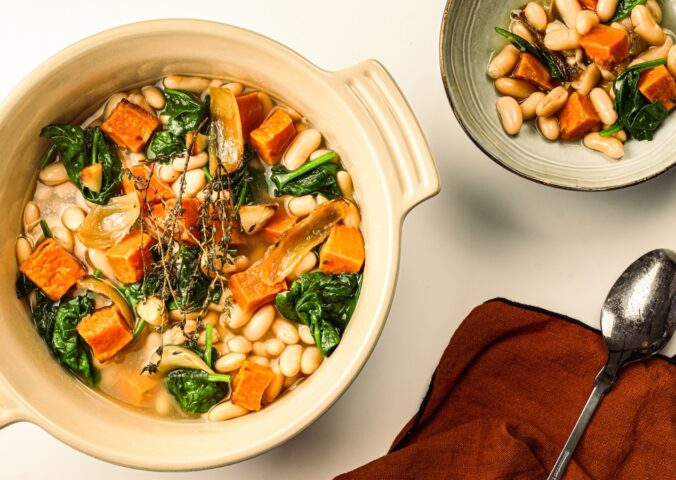 A pot of sweet potato one-pot warmer with spinach, white beans, and garlic