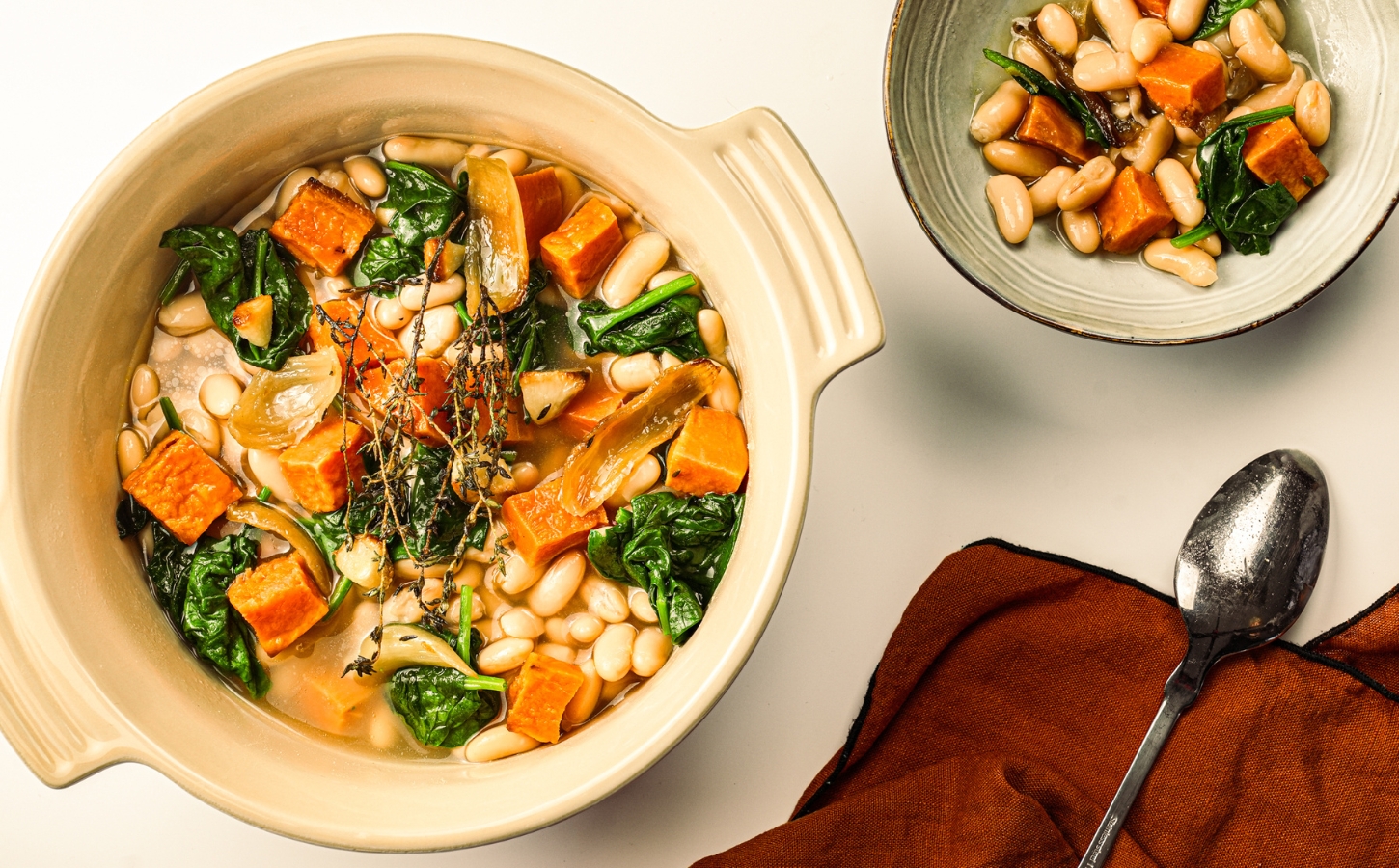 A pot of sweet potato one-pot warmer with spinach, white beans, and garlic