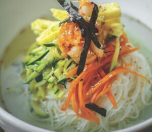 veggie noodles or janchi guksu with thin wheat noodles, radish, soy sauce, sliced onion, and zucchini