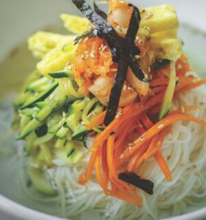 veggie noodles or janchi guksu with thin wheat noodles, radish, soy sauce, sliced onion, and zucchini