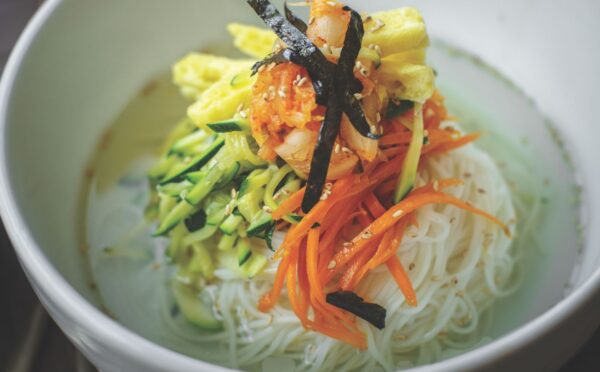 veggie noodles or janchi guksu with thin wheat noodles, radish, soy sauce, sliced onion, and zucchini