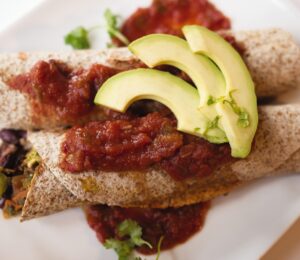 very veggie burritos or enchiladas with pepper, kale, beans, salsa, and avocado