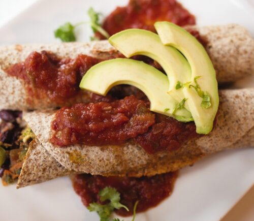 very veggie burritos or enchiladas with pepper, kale, beans, salsa, and avocado