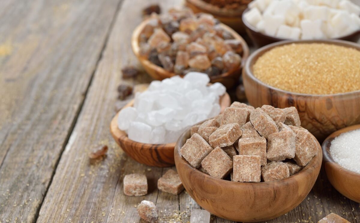 Different types of sugars in wooden bowls to illustrate article about the healthiest vegan sweeteners