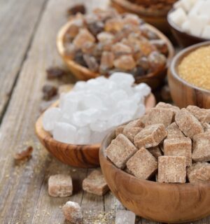 Different types of sugars in wooden bowls to illustrate article about the healthiest vegan sweeteners